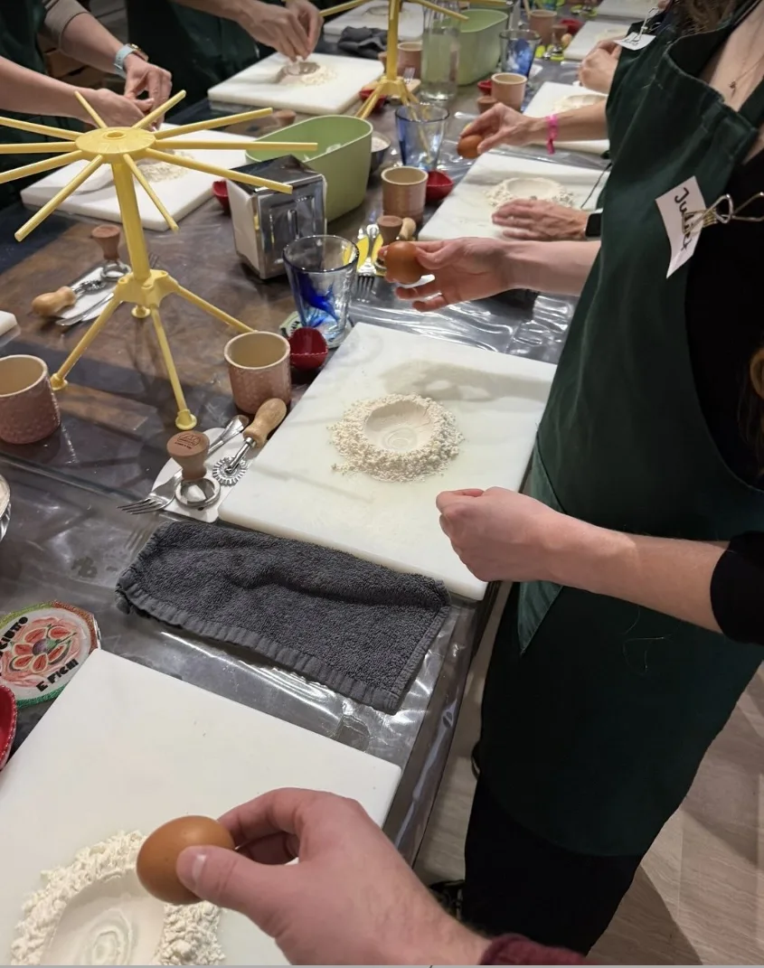 Guests making the egg well for fresh pasta during a pasta making class in Milan