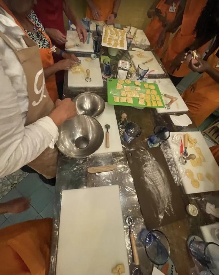 Guests in aprons shaping ravioli together