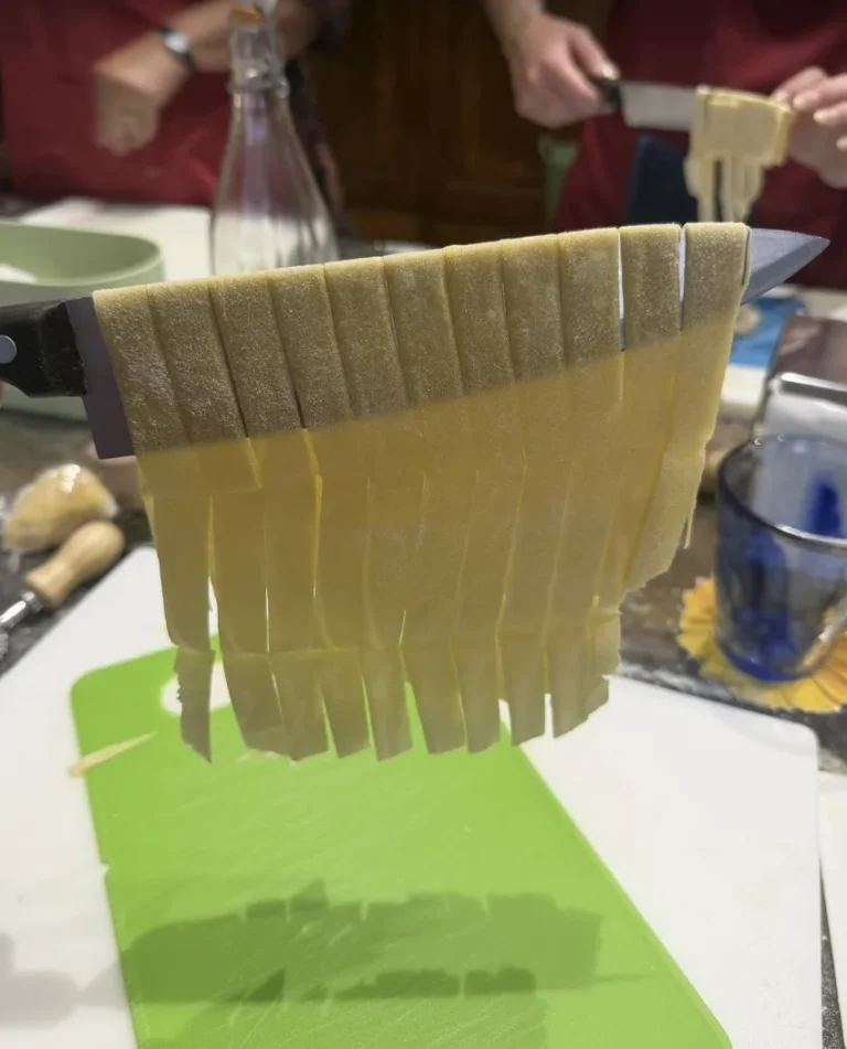 Fresh tagliatelle hanging from a knife